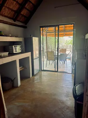 a living room with a door open to a patio at Athule Inn Marloth - Units in Marloth Park