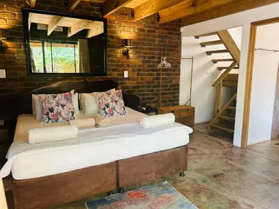a bedroom with a large bed in a brick wall at Athule Inn Marloth - Units in Marloth Park