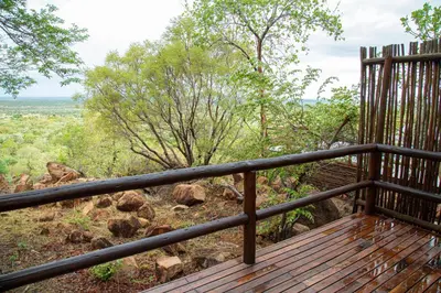 a wooden deck with a view of a field at Eclectic Safari Lodge in Mabula