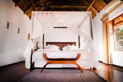 a bedroom with a white bed with a canopy at Shibula Safari Lodge in Welgevonden Game Reserve