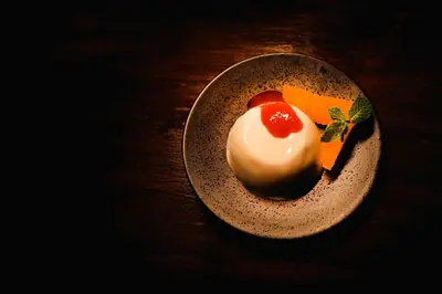 a plate with a dessert on a wooden table at Shibula Safari Lodge in Welgevonden Game Reserve
