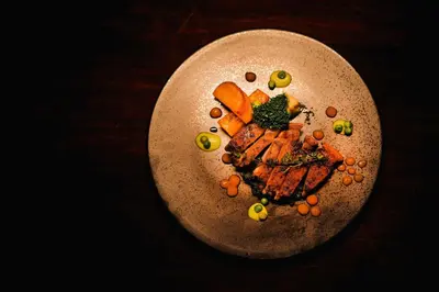 a plate of food with meat and vegetables on a table at Shibula Safari Lodge in Welgevonden Game Reserve