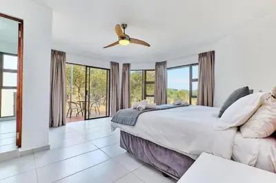 a bedroom with a bed and a ceiling fan at Nyala View, Mabalingwe in Mabula