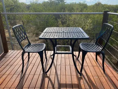 a table and two chairs sitting on a deck at Nyala View, Mabalingwe in Mabula