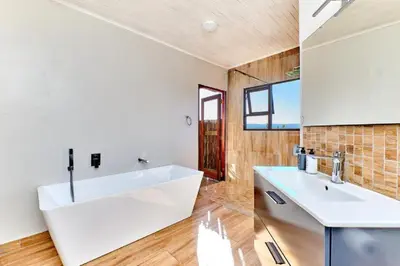 a bathroom with a white sink and a mirror at Nyala View, Mabalingwe in Mabula
