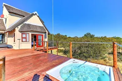a hot tub on the deck of a house at Nyala View, Mabalingwe in Mabula