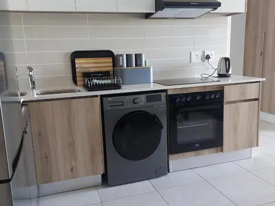 a kitchen with a washing machine and a sink at The Blyde River Walk Estate in Pretoria