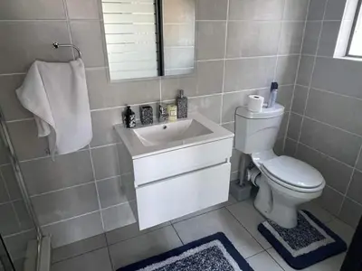 a bathroom with a white toilet and a sink at The Blyde River Walk Estate in Pretoria