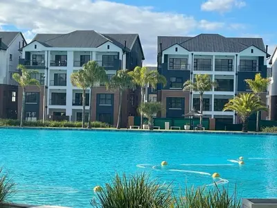 a swimming pool in front of some apartment buildings at The Blyde River Walk Estate in Pretoria