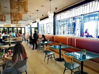 a restaurant with tables and chairs and people sitting at The Blyde River Walk Estate in Pretoria