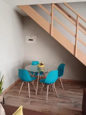 a dining room with a glass table and blue chairs at Private Room Chez Khanyi Homestays in Pretoria