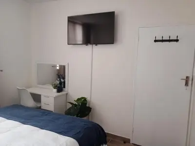 a bedroom with a bed and a tv on the wall at Private Room Chez Khanyi Homestays in Pretoria