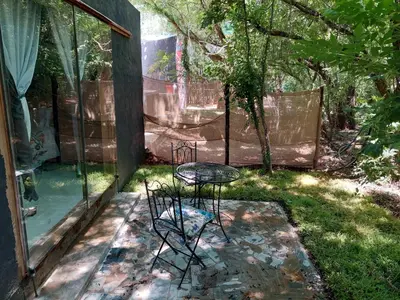 a patio with a table and chairs in the grass at Vulture's View 2 in Hartbeespoort