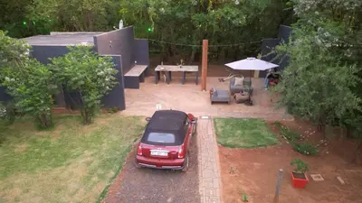 a red car parked in a yard with a picnic table at Vulture's View 2 in Hartbeespoort