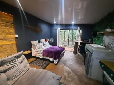 a living room with a bed and a window at Vulture's View 2 in Hartbeespoort