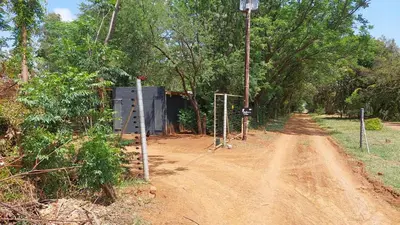 a dirt road with a building on the side at Vulture's View 2 in Hartbeespoort