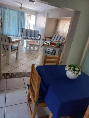 a living room with a blue table and chairs at Wildepeer in Nelspruit