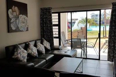 a living room with a leather couch and a table at Crystal lagoon View 3Bed Apartment in Pretoria