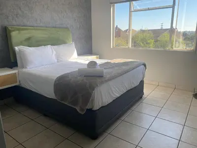 a bedroom with a bed with a large window at Menlyn Place in Pretoria