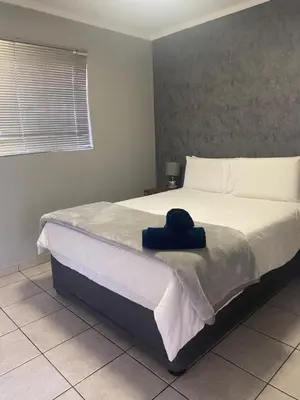 a bedroom with a bed with a hat on it at Menlyn Place in Pretoria