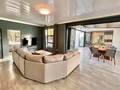 a living room with a large couch and a table at Stories @ Marloth in Marloth Park