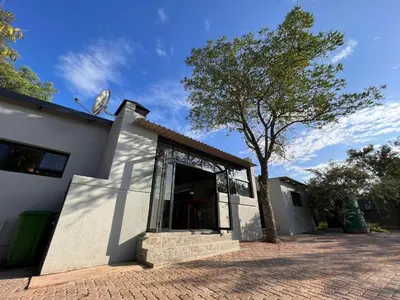 a white building with a tree in front of it at Stories @ Marloth in Marloth Park