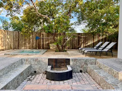 a backyard with a fire pit and a fence at Stories @ Marloth in Marloth Park