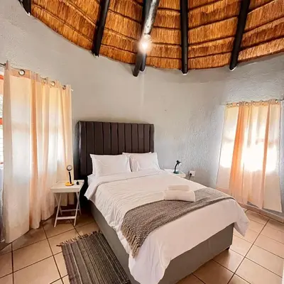 a bedroom with a large bed and a table at Indlovu Inn Guesthouse in Graskop