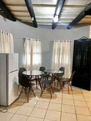 a dining room with tables and chairs and a refrigerator at Indlovu Inn Guesthouse in Graskop