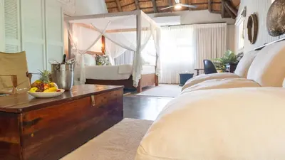 a bedroom with a bed and a table with a bowl of fruit at Vida Nova Kruger in Marloth Park