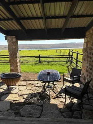 a patio with a table and a bench and a fence at La Vista Farm Stay in Ermelo