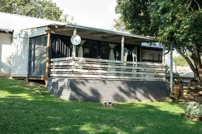 a screened in porch of a house in a yard at HomeSweetHome Farm Cottage in Nelspruit
