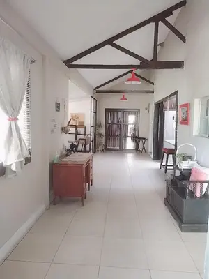 a living room with white tile floors and a table at HomeSweetHome Farm Cottage in Nelspruit