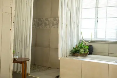 a bathroom with a tub and a window with a plant at HomeSweetHome Farm Cottage in Nelspruit