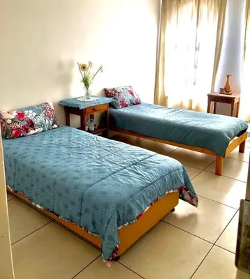 a bedroom with two beds and a table and a window at THEE VIEW in Hartbeespoort