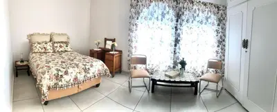 a bedroom with a bed and a table and chairs at THEE VIEW in Hartbeespoort