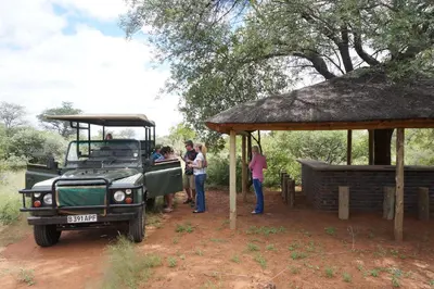 a group of people standing next to a truck at Kwele Game Lodge in Beauty