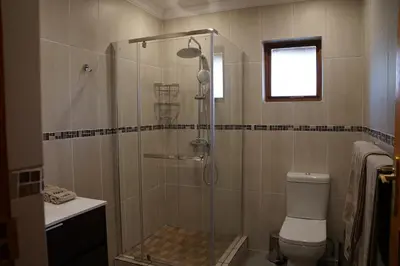 a bathroom with a shower with a toilet and a sink at Kwele Game Lodge in Beauty