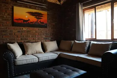 a living room with a couch and a brick wall at Kwele Game Lodge in Beauty
