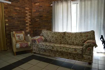 a living room with a couch and a window at Kwele Game Lodge in Beauty