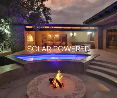 a fire pit in a backyard with a sign that reads solar powered at Chelesa by Kruger Nights in Marloth Park