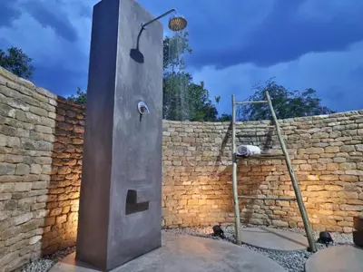a metal shower in front of a brick wall at Chelesa by Kruger Nights in Marloth Park