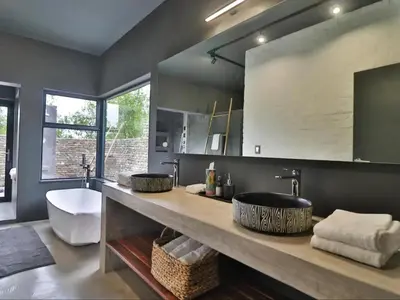 a bathroom with two sinks and a large mirror at Chelesa by Kruger Nights in Marloth Park