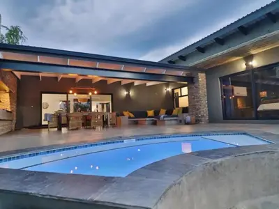 a swimming pool in front of a house at Chelesa by Kruger Nights in Marloth Park