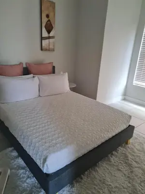 a bed sitting in a room with a window at Luxury 264 The Blyde in Pretoria