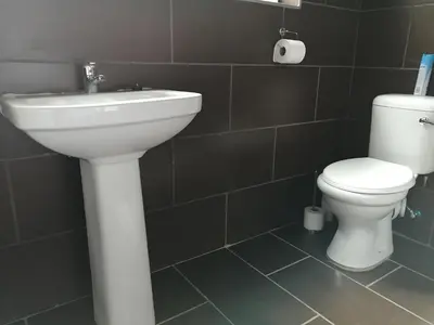 a bathroom with a white sink and a toilet at Shai's Studio in Centurion
