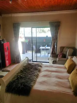 a bedroom with a large bed with a rug on it at Shai's Studio in Centurion