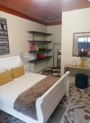 a bedroom with a white bed and a desk at Shai's Studio in Centurion