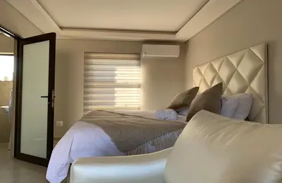a bedroom with a large bed and a window at Yami Nawe Lodge in Dennilton