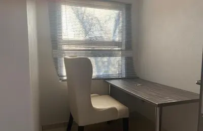 a chair sitting in front of a desk with a window at Yami Nawe Lodge in Dennilton